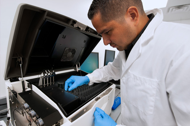 lab technician using microbial detection instrument