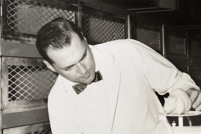 Photo of Henry Foster with a white mouse on a scale