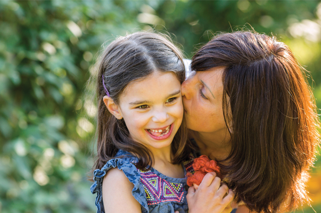 The Vital Science podcast episode 01 is an image of Julia Vitarello kissing her daughter Mila on the cheeck, as both smile.