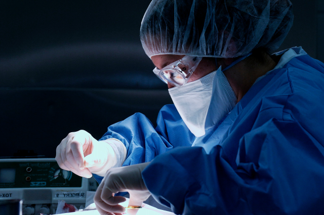 male surgeon suturing