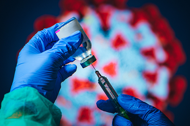 Vital Science season two episode 4 image of gloved hands holding a syringe and vaccine vial in front of an image of the COVID-19 virus cells.