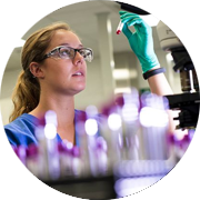 Lab tech in a Charles River clinical pathology lab holding a test tube filled with serum for analysis.