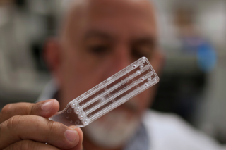 Laboratory technician holding FDA-licensed Endosafe endotoxin cartridge