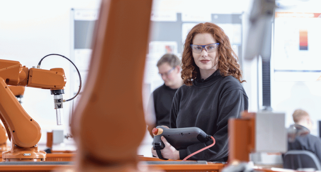 Woman in lab surrounded by robots. Depicts automation in lab sciences