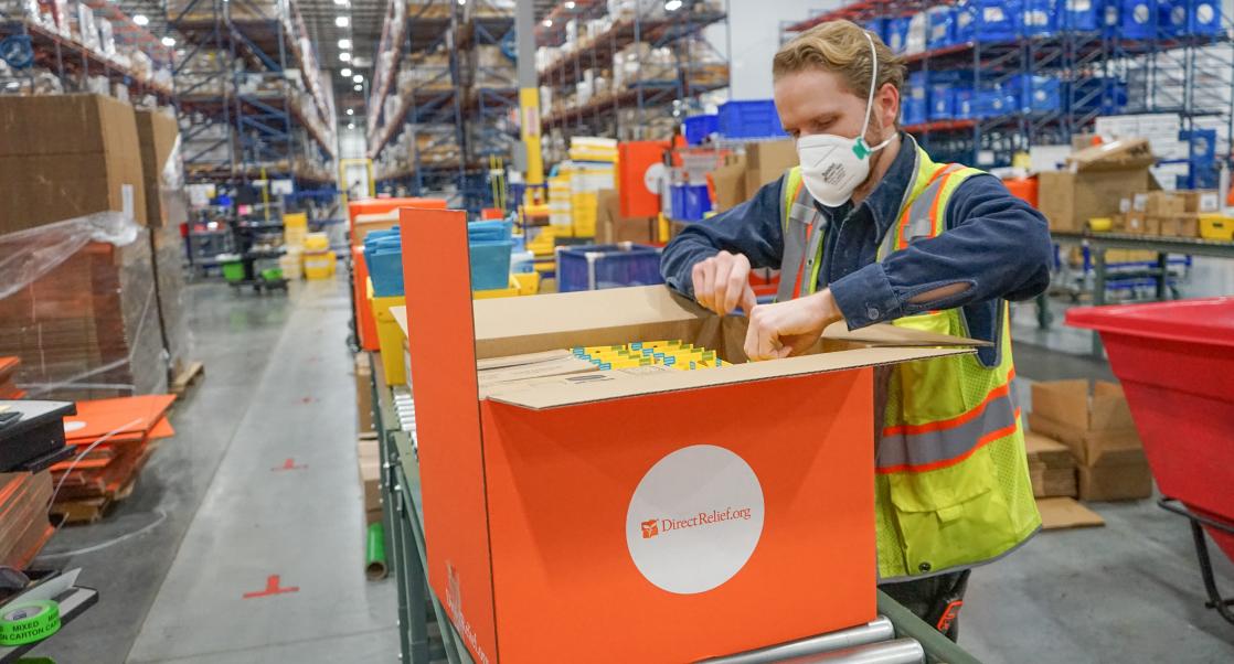 Direct Relief worker packs kit for distribution