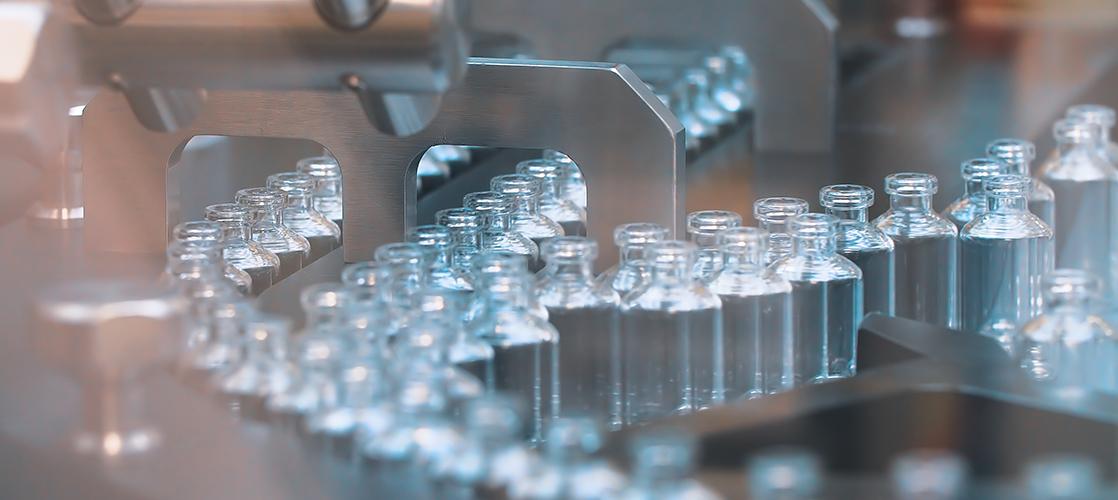 vaccine bottles on an assembly line